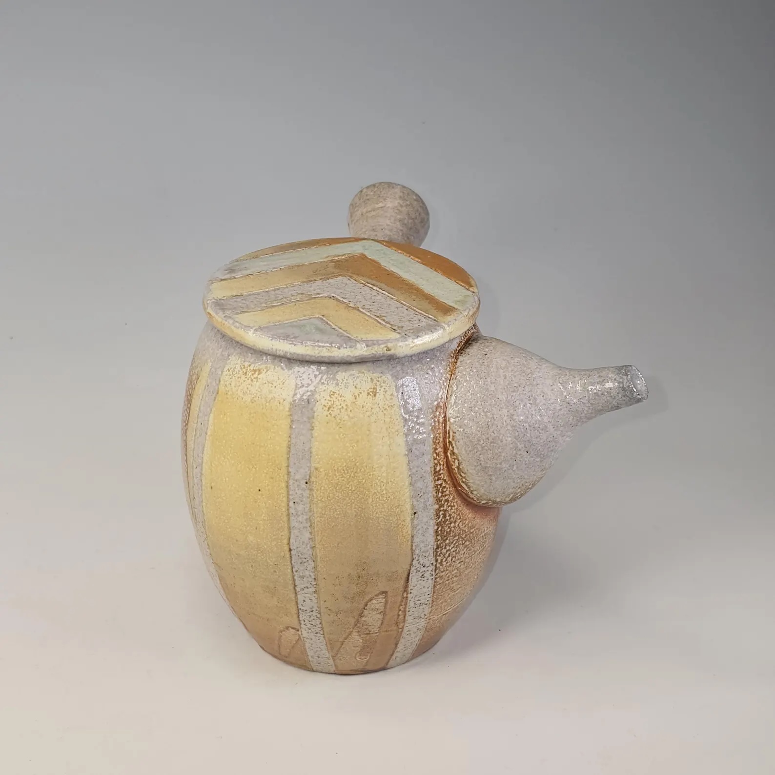 Soda-fired ceramic teapot and pouring vessel with slip decoration